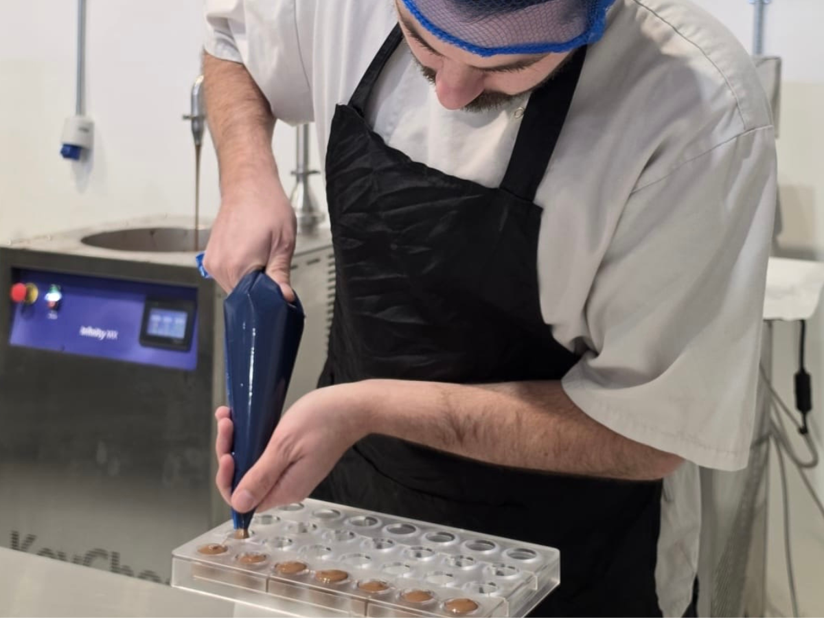 Buíoch chocolatier piping filling into a chocolate mould
