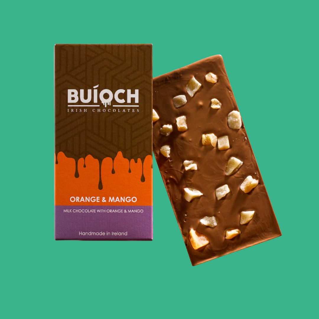 Orange and Mango Bar - Milk chocolate with oreange and mango. Handmade by Buíoch Irish Chocolates. Packaging and bar on a mint green background.