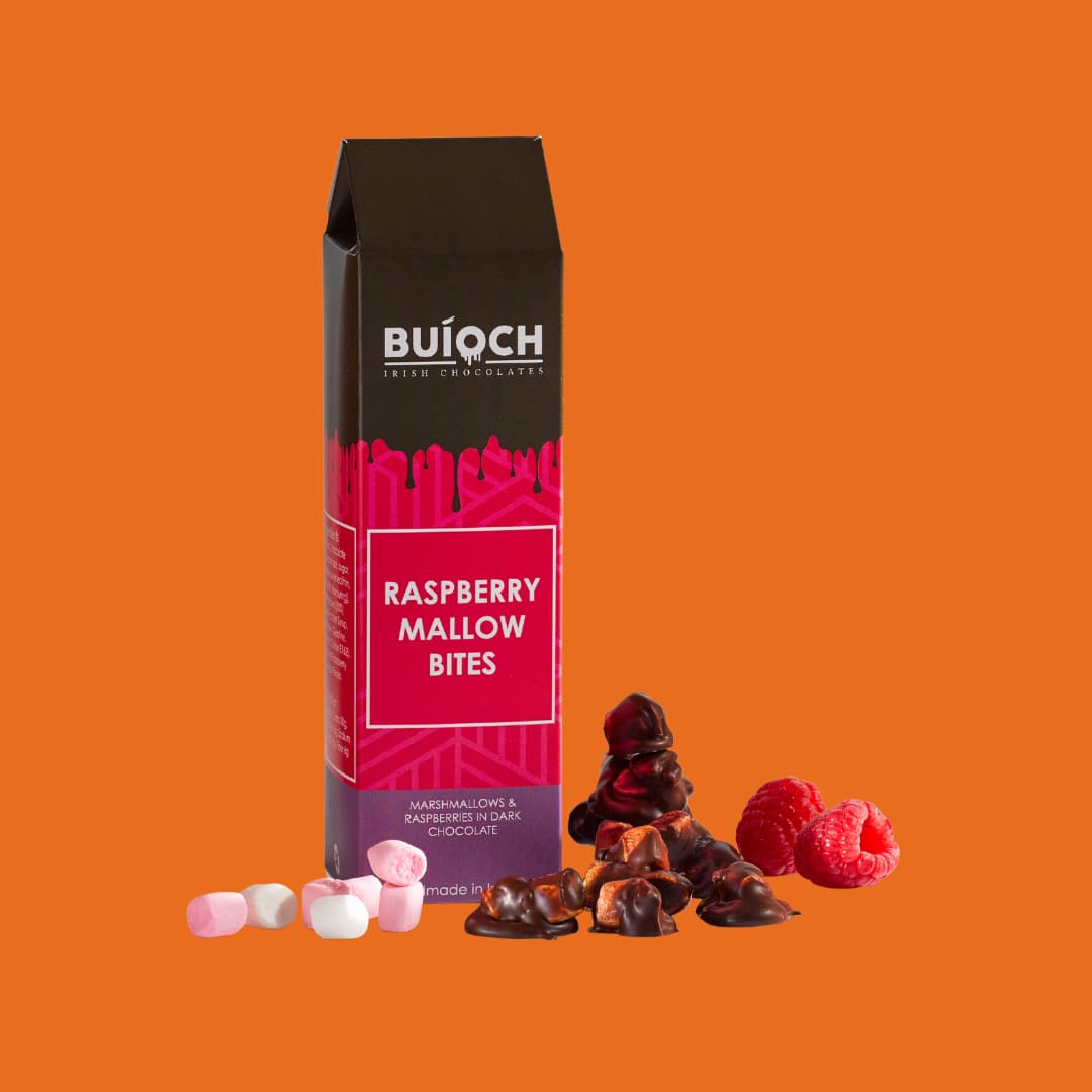 Raspberry Mallow Bites - Marshmallow and Raspberries in Dark Chocolate. Handmade by Buíoch Irish Chocolates. Packaging on an orange Background.