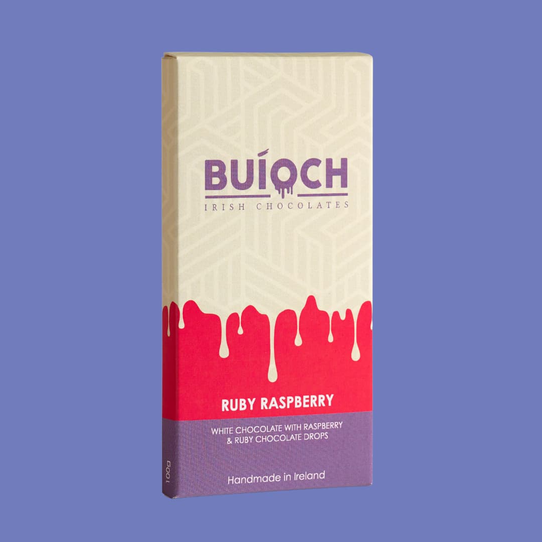 Ruby Raspberry Bar - White chocolate with raspberry and ruby chocolate drops. Handmade by Buíoch Irish Chocolates. Packaging on a blue background.