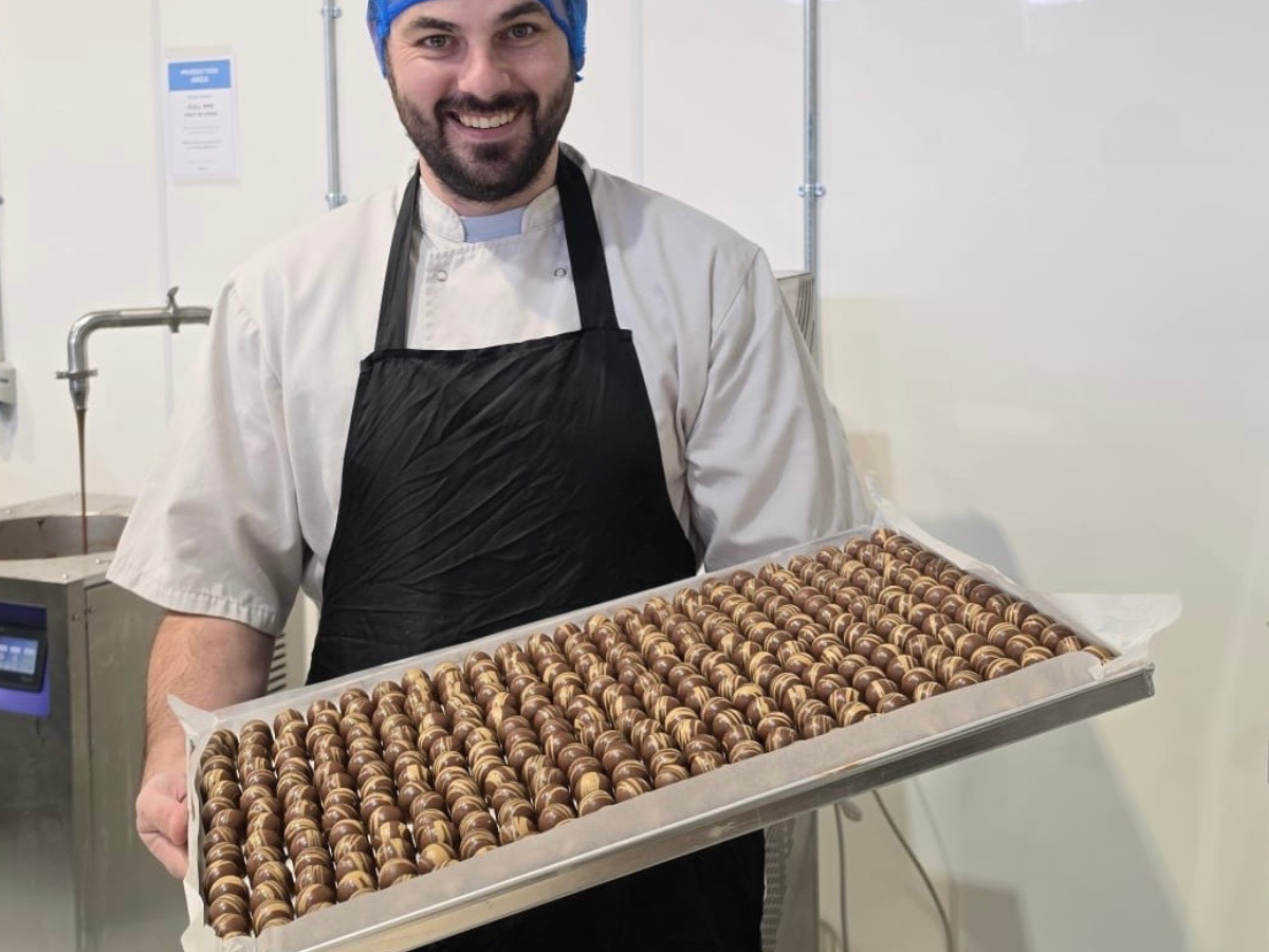 Buíoch chocolatier holding a tray of hand-decorated chocolates in the kitchen
