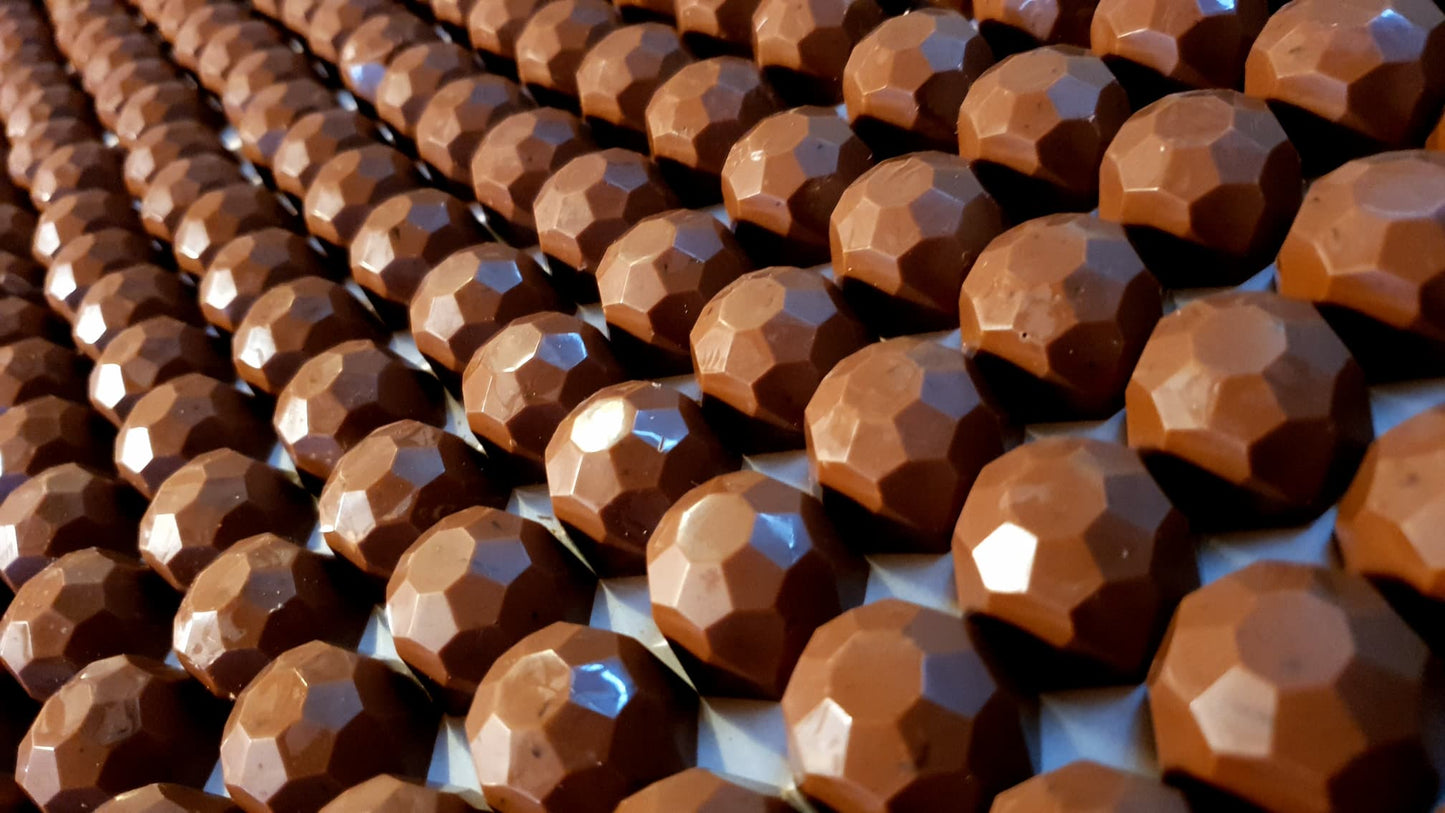 Salted caramel milk chocolate clusters, handmade by buioch Irish chocolates. Laid out as rows and rows of chocolate clusters. 