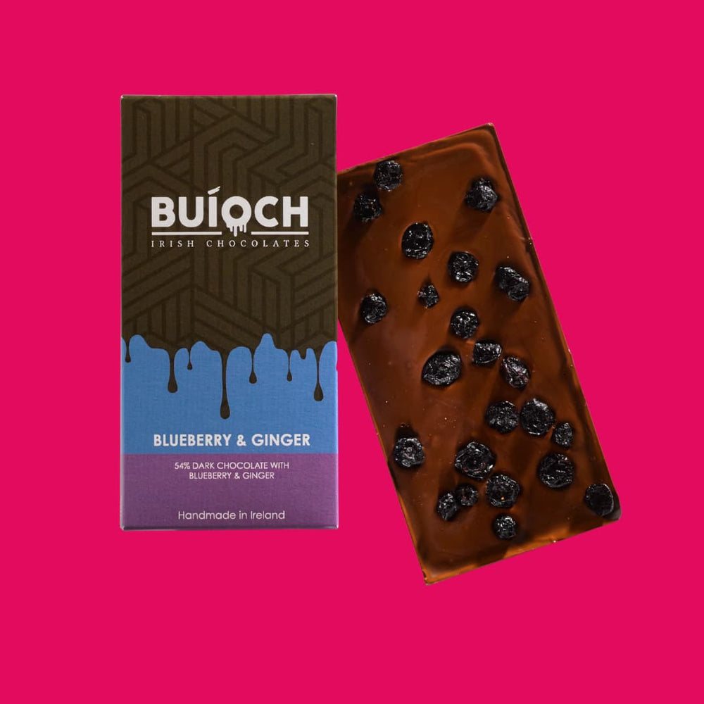 
                  
                    Blueberry and Ginger Bar - 54% dark chocolate with blueberries and ginger. Handmade by Buíoch Irish Chocolates. Packaging and bar on a pink background.
                  
                