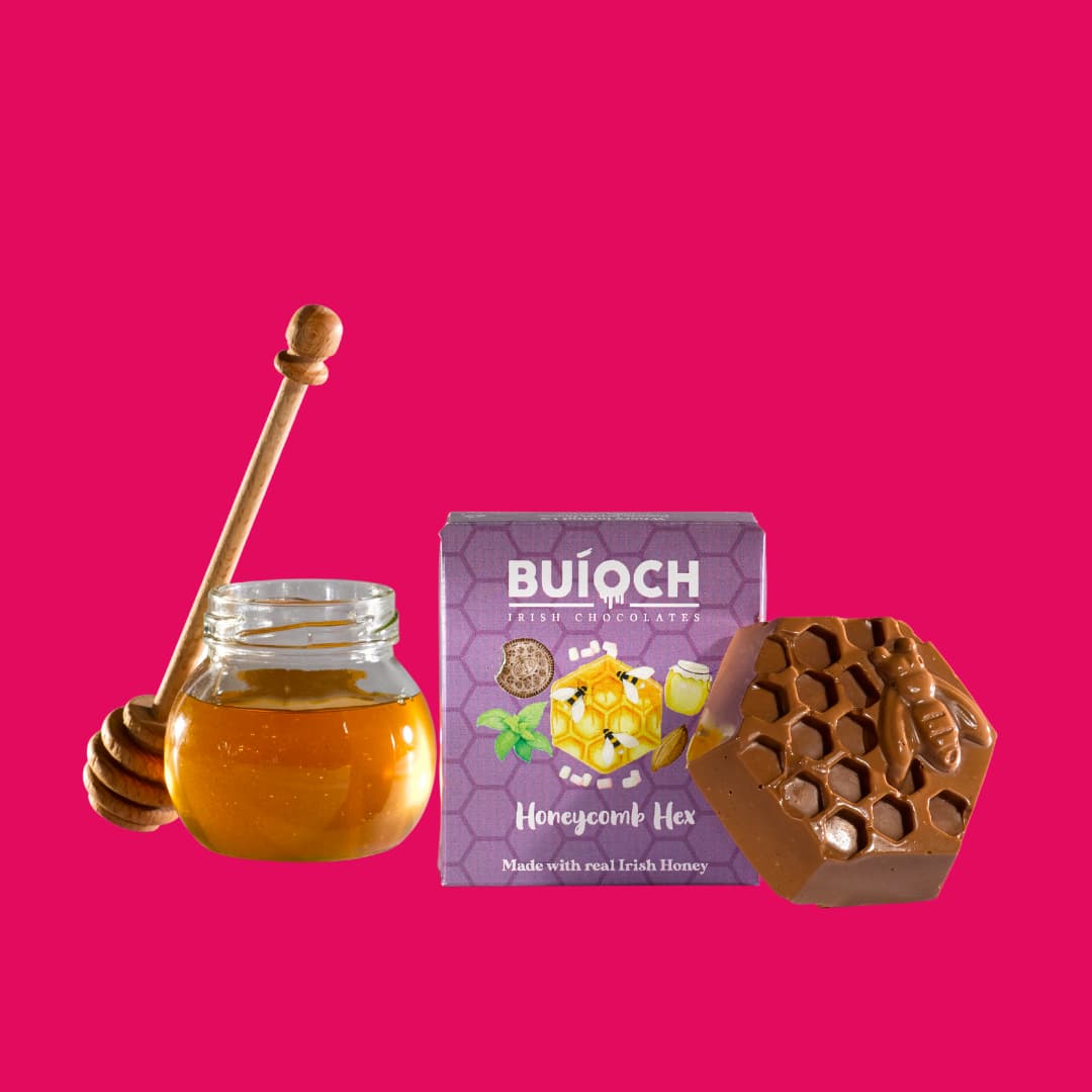 
                  
                    Milk Chocolate Honeycomb Hex - Packaging on a pink background. Handmade by Buíoch Irish Chocolates.
                  
                
