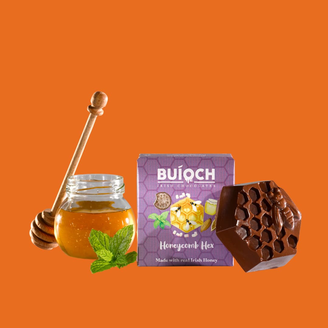 
                  
                    Mint Dark Chocolate Honeycomb Hex - Packaging on an Orange background. Handmade by Buíoch Irish Chocolates.
                  
                