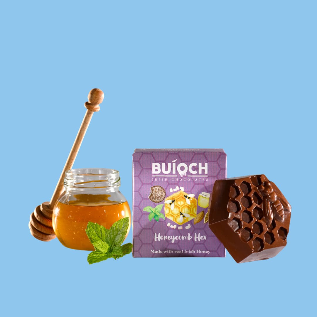 
                  
                    Mint Dark Chocolate Honeycomb Hex - Packaging on a sky blue background. Handmade by Buíoch Irish Chocolates.
                  
                