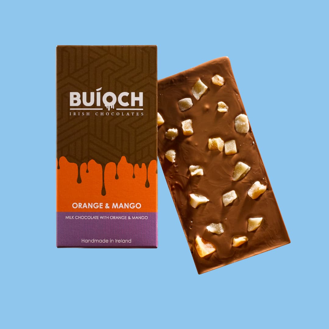 
                  
                    Orange and Mango Bar - Milk chocolate with oreange and mango. Handmade by Buíoch Irish Chocolates. Packaging and bar on a blue background.
                  
                