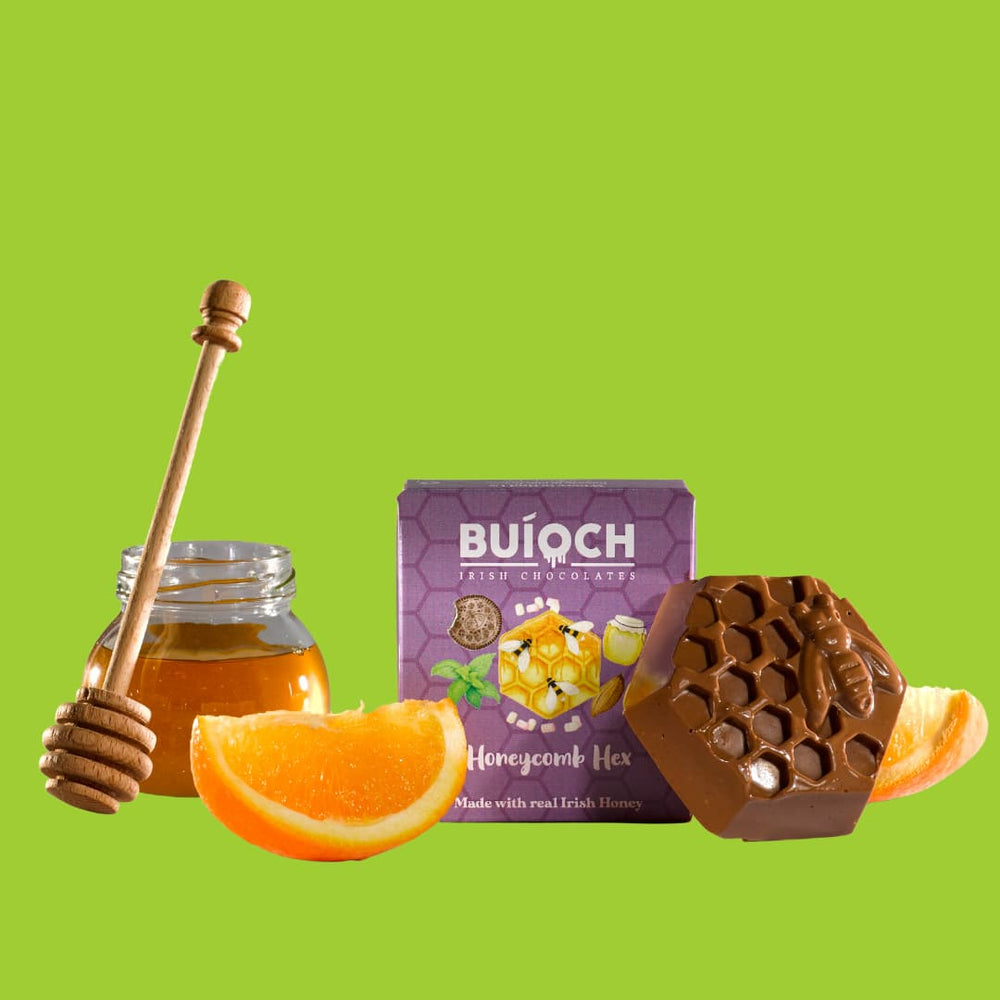 
                  
                    Orange Milk Chocolate Honeycomb Hex - Packaging on a Lime Green background. Handmade by Buíoch Irish Chocolates.
                  
                