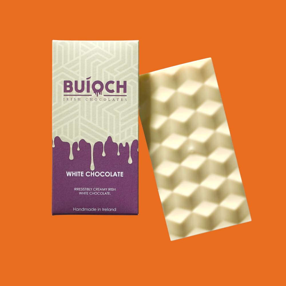 White Chocolate Bar. Handmade by Buíoch Irish Chocolates. Packaging and bar on an orange background.